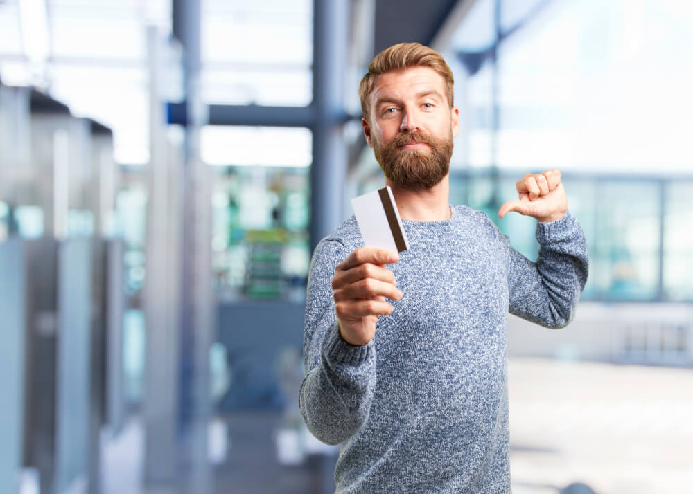 blonde man holding credit card